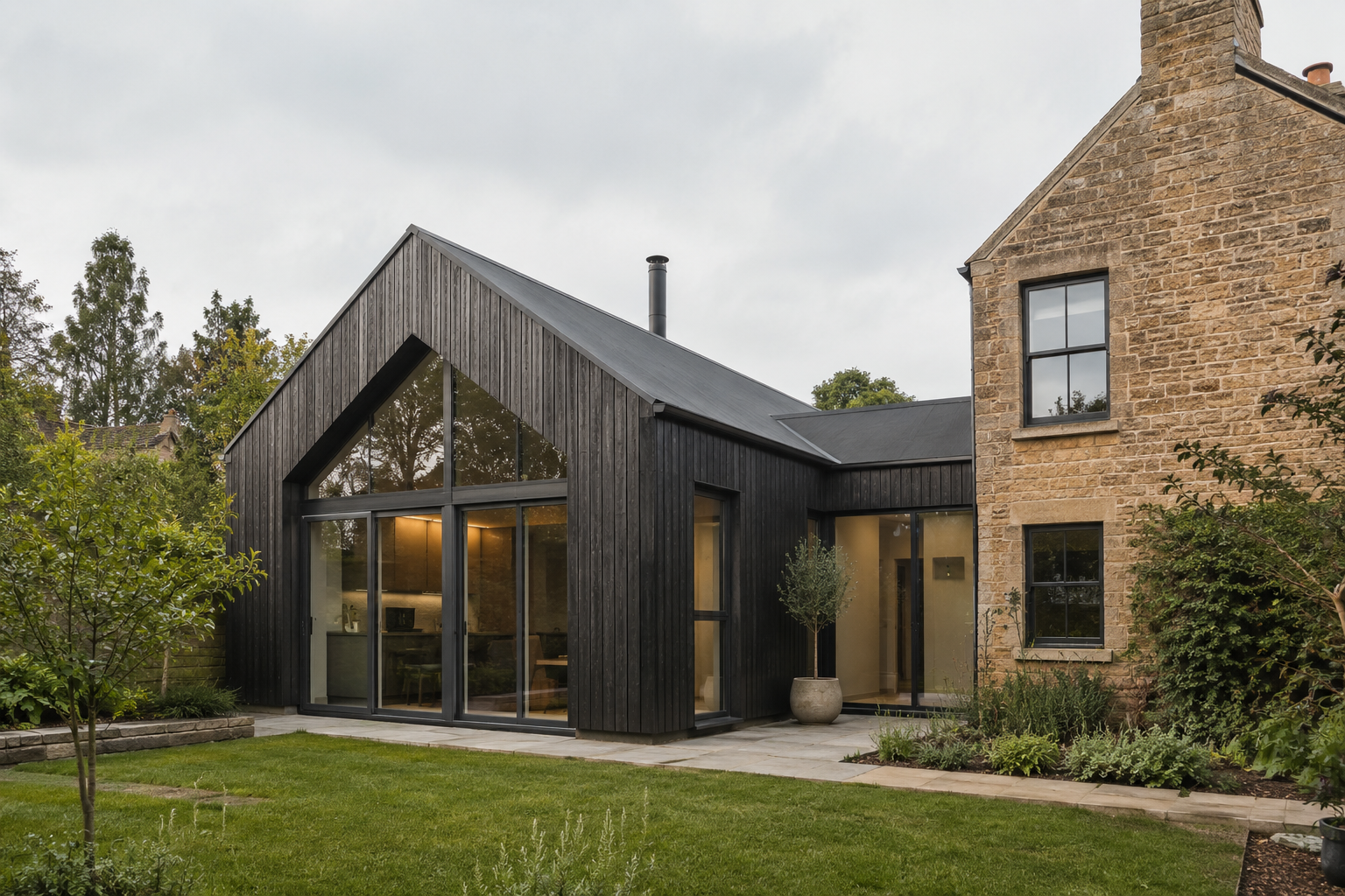 Photorealistic black timber-clad gabled extension with large glazed openings connected to a stone home